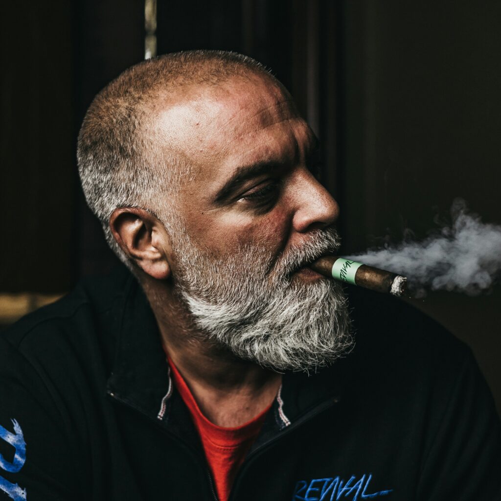 a man with a beard smoking a cigarette